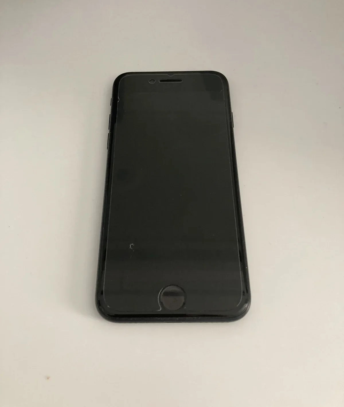 約1年使っているiPhone SE3の前面。ホームボタンと保護フィルムが見える